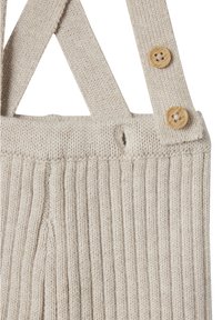 Beige, gerippte Strickträger mit zwei Holzknöpfen, die einen Träger am Taillenbund befestigen.