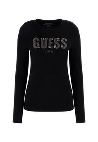 Camicia nera a maniche lunghe in cotone con scollatura rotonda. Presenta il testo "GUESS" in strass argentati e l'anno di fondazione 1981 sottostante.