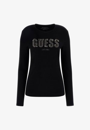 Black long-sleeve shirt made of cotton with a rounded neckline. Features silver rhinestone "GUESS" text and established year 1981 below.