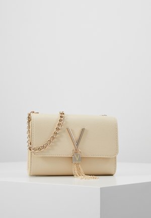 Beige struktureret læder crossbody taske med guldkæde, guld "V" logo og kvast vedhæng på hvid overflade.