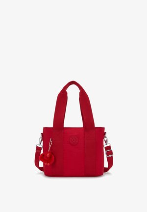 Rote Nylon-Tragetasche mit zwei Griffen, verstellbarem Schultergurt und einem kleinen Plüschaffen-Schlüsselanhänger, der an der vorderen linken Seite befestigt ist.