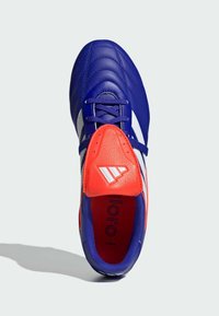 Zapatilla de fútbol azul con textura de cuero, que presenta un acento en rojo y blanco, diseño acolchado y cordones. Interior marcado con "COPA."