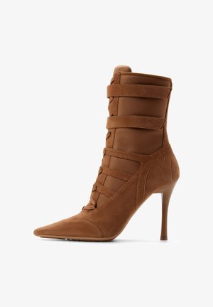 Brauner Wildleder-Stiefelette mit hohem Absatz, spitzer Zehenpartie, Schnürung vorne und drei horizontalen Riemen um den Schaft.