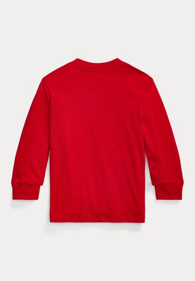 Raudonas ilgomis rankovėmis marškinėlis, pagamintas iš minkšto medvilnės, turi apvalų kaklą, tiesų apatinį kraštą ir ribotas rankogalius. Lygus paviršius be matomų raštų.