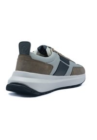 Sneakers med en grå mesh-övre, bruna mockadetaljer, svart hardvara och en tjock vit sula. Bakre dragtab för enkel påtagning.