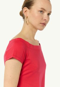 Czerwona bluzka z krótkim rękawem o kwadratowym dekolcie i dopasowanym kroju, wykonana z miękkiej bawełny, charakteryzująca się gładką teksturą i minimalnymi szwami.