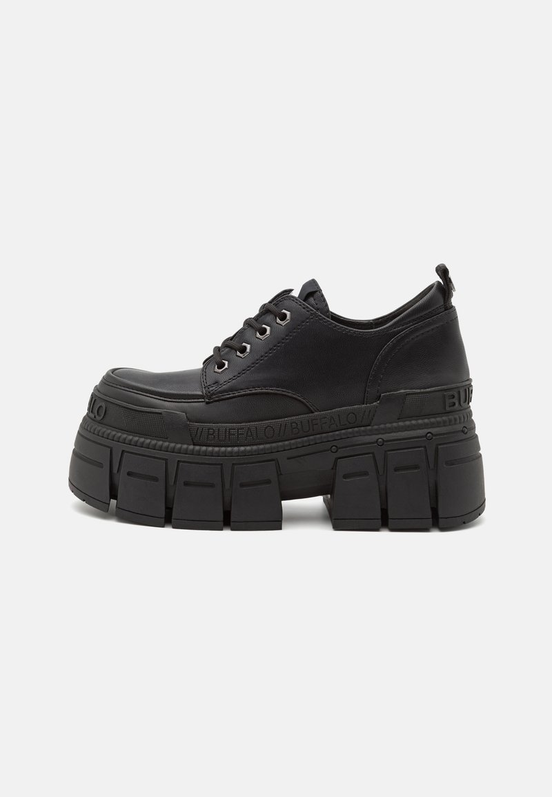 Chaussure plateforme noire à semelle épaisse et rainurée, fermeture à lacets sur l'avant, avec la marque "BUFFALO" sur la semelle intermédiaire et la languette talonnière.