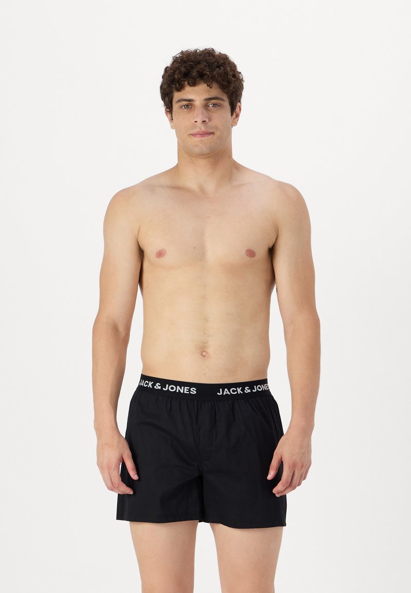Čierne boxerky s elastickým pásom, na ktorom je biele logo "JACK & JONES". Vyrobené z ľahkej tkaniny a s voľným strihom.