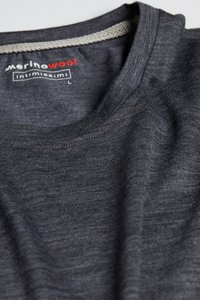 Tmavě šedé merino vlna tričko s kulatým výstřihem a texturovaným světle šedým lemem na límci. Obsahuje štítek s názvem značky a velikostí.