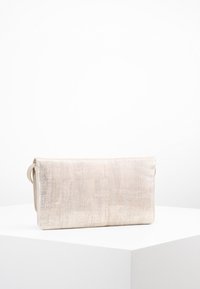 Bolso de mano beige metálico con superficie texturizada, forma rectangular y cierre de solapa. Presenta un diseño delgado y herrajes mínimos.