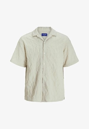 Koszula z krótkim rękawem w jasnym beżu z teksturowanym wykończeniem. Posiada zapięcie na guziki z przodu i klasyczny kołnierzyk.