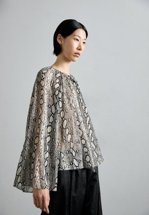 Blusa leggera e trasparente con stampa a serpente in tonalità di beige e nero; presenta maniche a campana e una scollatura rotonda.