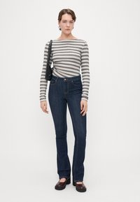 ΡΙΓΕ ΜΑΚΡΥΜΑΝΙΚΗ ΜΠΛΟΥΖΑ ΣΕ ΓΚΡΙ ΚΑΙ ΜΠΕΖ. ΨΗΛΟΜΕΣΑ ΣΚΟΥΡΑ ΜΠΛΕ ΤΖΙΝ ΜΕ ΦΛΕΡΑ. ΚΑΦΕ ΠΛΑΤΦΟΡΜΕΣ. ΜΑΥΡΗ ΤΣΑΝΤΑ ΧΕΡΙΟΥ.