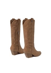 Par de botas vaqueras de ante color tostado hasta la mitad de la pantorrilla con tacones apilados, cremalleras laterales y costuras decorativas perforadas sobre un fondo blanco.