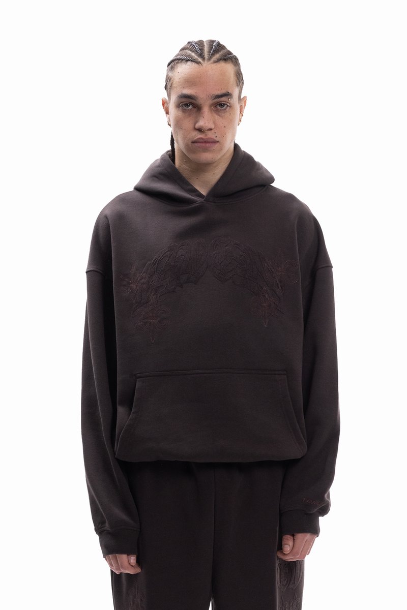 Temno rjava jopica s kapuco iz mehke tkanine. Ponaša se z žepom spredaj in prefinjenim toniranim vezenjem na prsih. Ohlapen kroj.