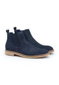 Navy blauwe suède enkelboots met elastische zijpanelen, trekriemen en een lichtbruine crepezool. Glad textuur met een ronde neusdesign.