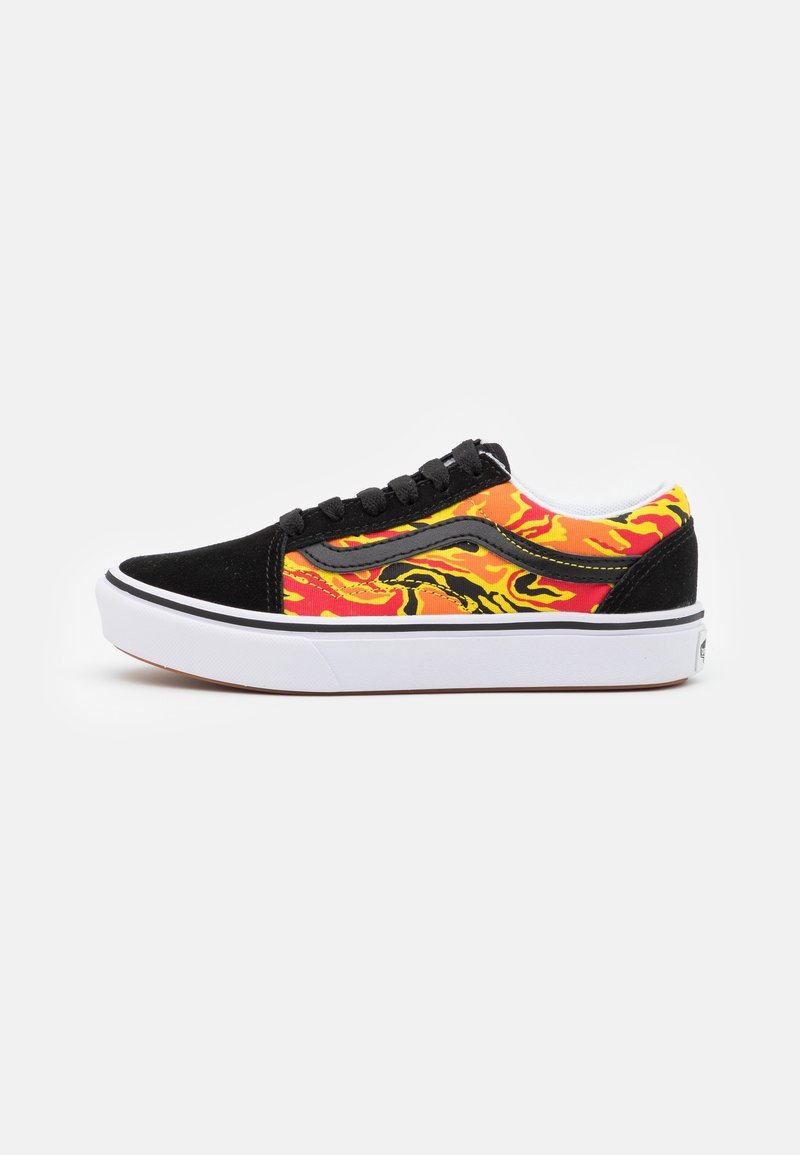 Chaussures de skate en daim noir et toile colorée avec un motif abstrait rouge, orange et jaune, une semelle intermédiaire blanche et des lacets noirs.
