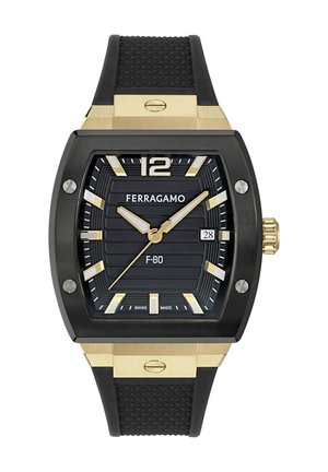 Black digital watch with a rectangular case, gold accents, and a textured rubber strap. Features a ridged black dial with gold markers and date function.