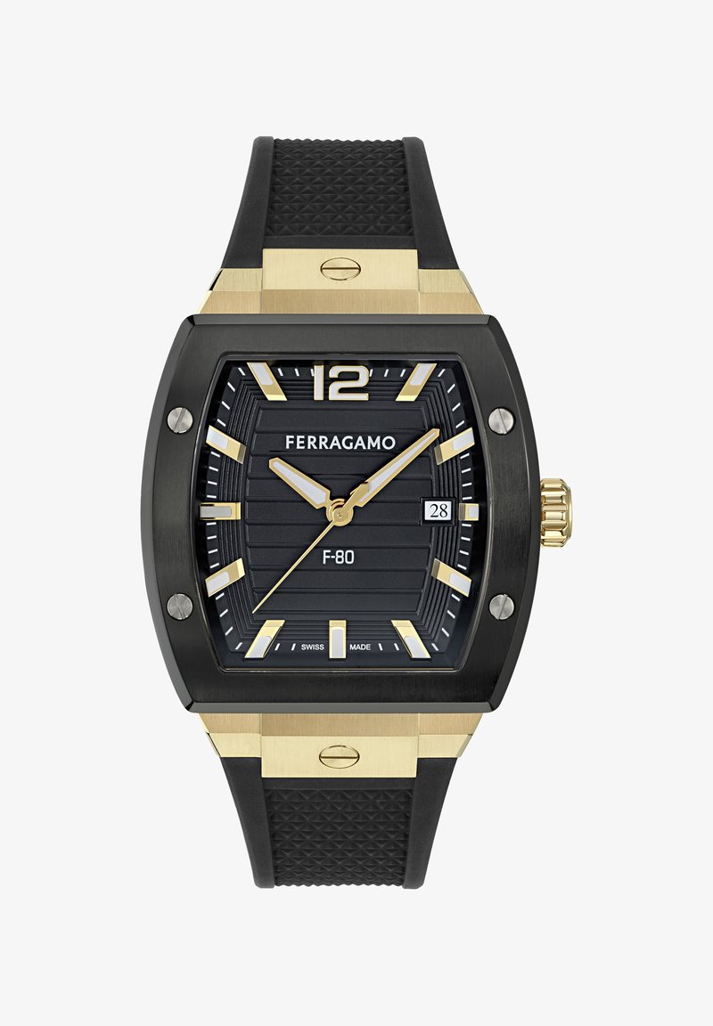 Fekete digitális óra téglalap alakú tokban, arany díszítésekkel és texturált gumiszíjjal. Barázdált fekete számlappal rendelkezik, arany indexekkel és dátum funkcióval.