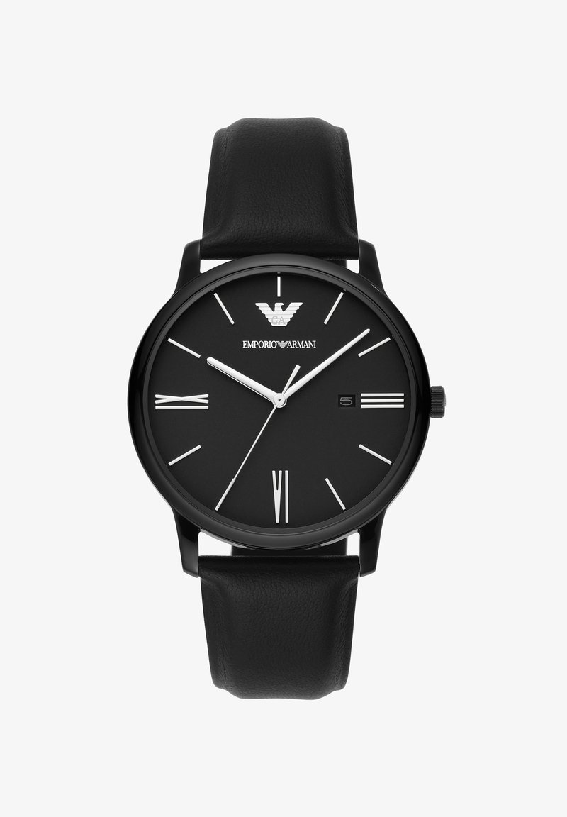 Reloj analógico negro con una esfera negra mate, marcadores de hora blancos y una correa de cuero. Presenta una ventana para la fecha a las 4 en punto y un logo a las 12 en punto.