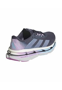 Scarpa atletica viola e grigia con tomaia in rete, design a tre strisce, suola stratificata con accenti di blu chiaro e rosa, e battistrada testurizzato.