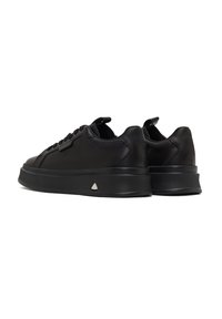 Sneakers in pelle nera con finitura liscia, punta rotonda, lacci piatti e suola texturizzata, con un accento triangolare sul tallone.