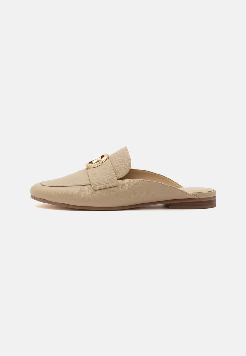 Μπεζ φλατ μοκασίνι slip-on με στρογγυλεμένη μύτη, υφασμάτινη υφή, φαρδιά λουράκι και χρυσή κυκλική αγκράφα σε λευκό φόντο.