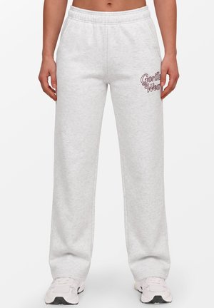 Witte sweatpants met elastische tailleband, zijzakken, "Gorilla Wear" logo op de bovenste dij, gedragen met witte sneakers.