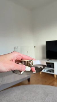 Savannah-nahkavyö suorakulmaisella kultaisella soljella, jossa on geometrinen kuvio. Tasainen pinta, rullattu muoto ja kiiltävä viimeistely.