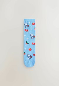 Light blue socks featuring a repeating pattern of Snoopy, red bows, and flowers, with a soft texture and a standard crew length design.