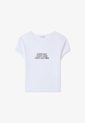 T-shirt bianco in cotone con maniche corte e scollatura rotonda, con testo nero che recita "MI DISPIACE MA NON MI PREOCCUPA CIÒ CHE PENSI."