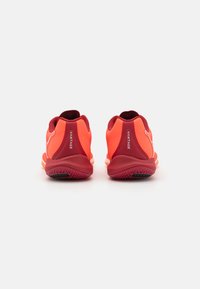Scarpe sportive con una combinazione di colori rosso e arancione brillante, dotate di una suola testurizzata e un tallone imbottito per il comfort.