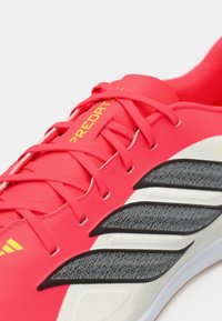 Φωτεινό ροζ αθλητικό παπούτσι με μαύρες και λευκές λεπτομέρειες. Διαθέτει υφή στην επάνω πλευρά, κορδόνια και σήμανση. Κομψός σχεδιασμός για απόδοση.