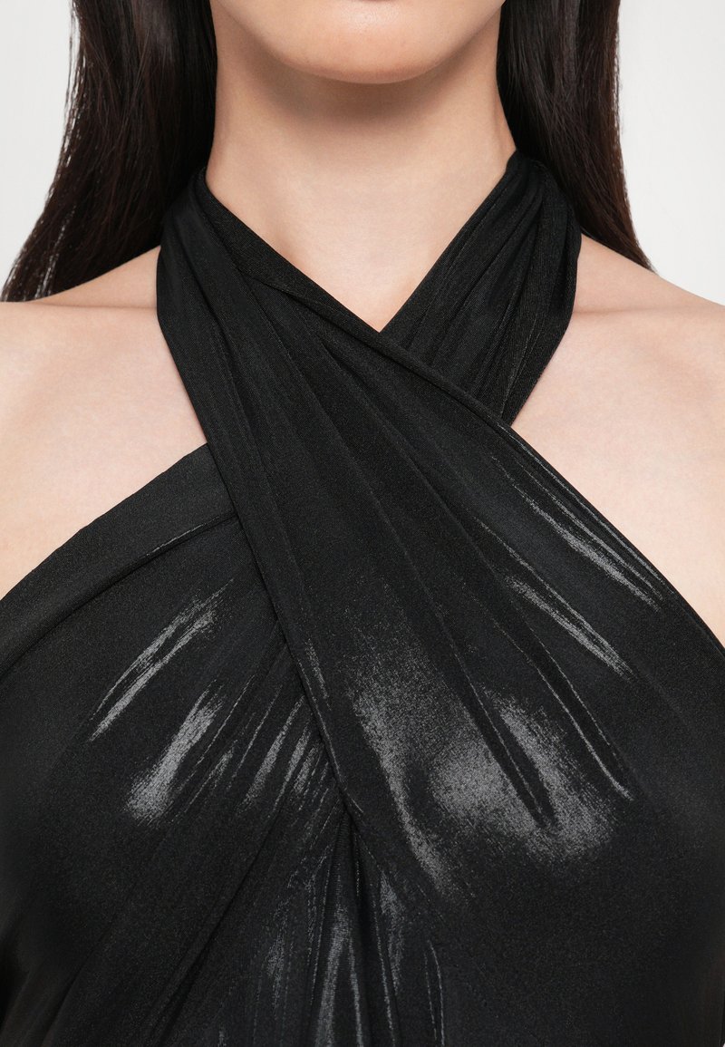 Top negro de halter con un diseño drapeado y un acabado brillante. El material parece suave y ligero, con acentos de tela cruzados en el escote.