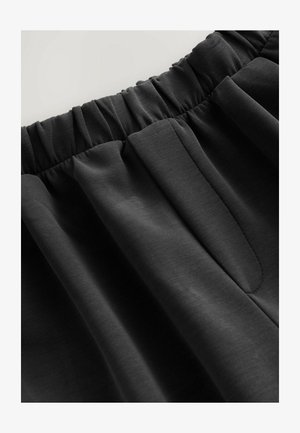 Black pull-on pants with gathered elastic waistband, featuring a smooth texture and two side pockets. Simple and functional design.