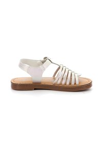 Sandalias planas metálicas plateadas con una suela marrón y una correa de talón ajustable, que presentan múltiples tiras finas en la parte frontal.