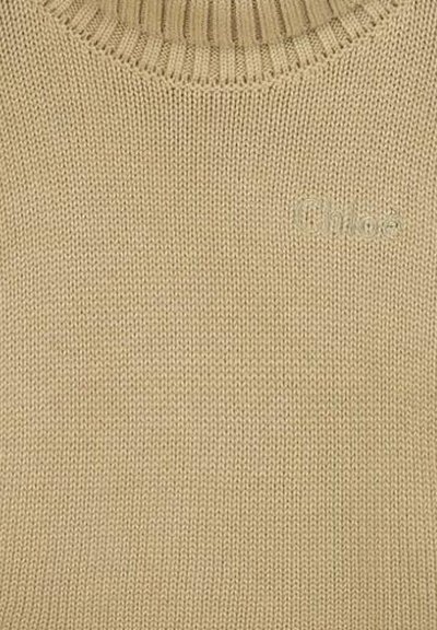 Maglione beige in maglia con un collo alto a coste e il sottile logo "Chloé" ricamato nello stesso colore. Tessuto morbido e design leggero.