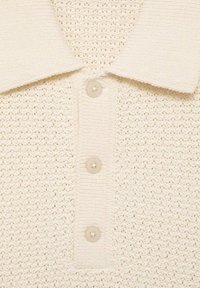 Gebreide polo shirt in off-white met een gestructureerd patroon, voorzien van een omgeslagen kraag en vier beige knopen langs de halslijn.