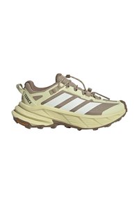 Trail running shoe in beige and brown with white stripes, rugged sole, and quick-lace system, designed for outdoor activities.