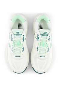 White athletic sneakers with mint green accents and mesh panels. Features laces, a cushioned tongue, and a textured rubber sole.