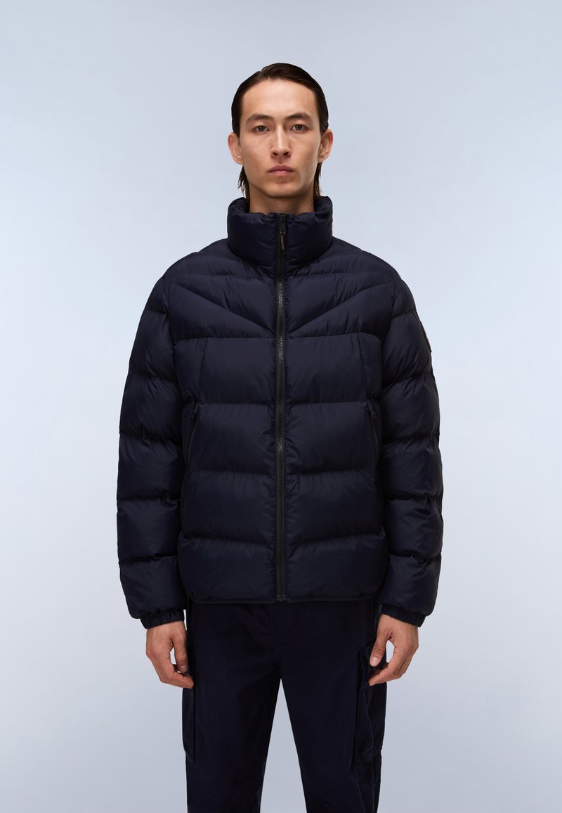 Chaqueta de plumas azul marino con cuello alto, diseño de acolchado horizontal, cremallera frontal y bolsillos laterales. La tela parece suave y ligeramente brillante.