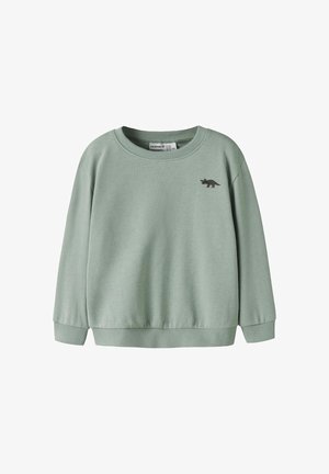 Jasnozielona dziecięca bluza z prążkowanymi mankietami i dołem, z małą grafiką dinozaura na lewej piersi.