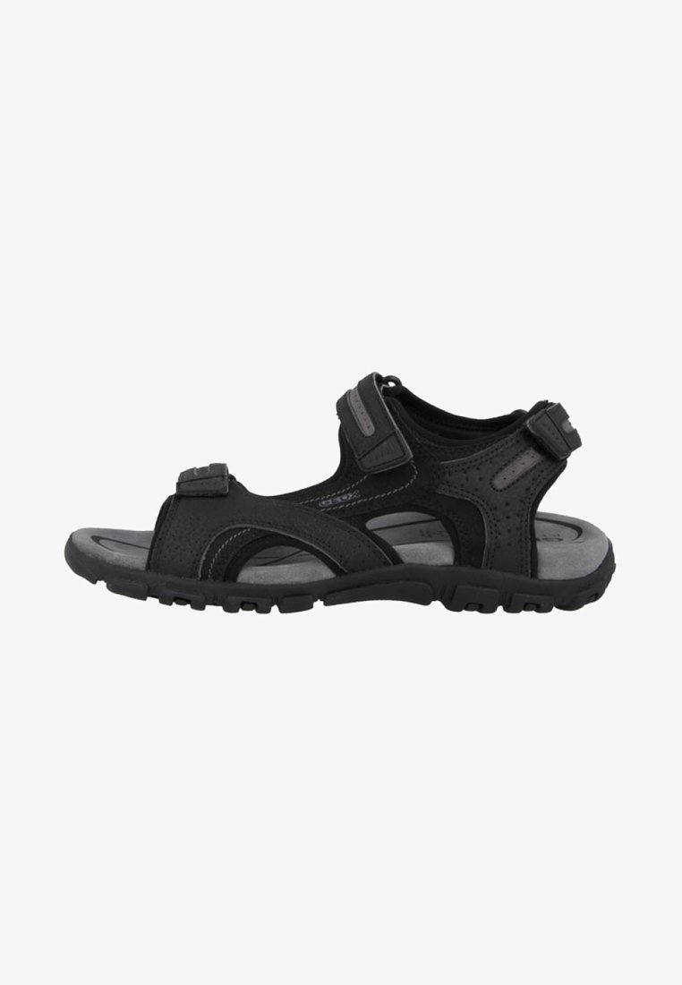 Sandal preto com tiras ajustáveis, material respirável, sola texturizada e uma sola de borracha resistente com um padrão de ranhura para aderência.