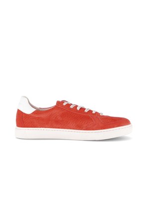 Rode suède lage sneaker met perforaties, witte zool, witte hieltab en witte veters, getoond in profiel op een witte achtergrond.