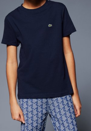 Navyblauwe katoenen t-shirt met ronde hals, korte mouwen en een klein groen krokodillenlogo op de linkerborst.