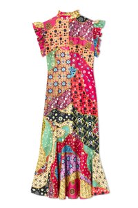 Maxi-jurk met een patchworkontwerp en levendige patronen in roze, groen, geel en zwart. Ruches op de mouwen accentueren de halslijn.