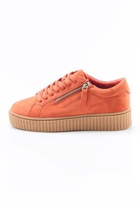 Sneaker en daim orange avec une semelle en caoutchouc texturée, présentant des lacets ronds et un détail de fermeture éclair sur le côté. Doublure intérieure lisse.