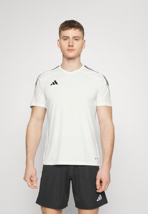 Witte sportieve shirt met korte mouwen en zwarte zijsstripes. Heeft een V-hals en het Adidas-logo op de linker borst. Gemaakt van ademend materiaal.