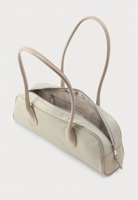 Ορθογώνια μπεζ τσάντα χειρός με μακριά λουριά ώμου, το επάνω φερμουάρ ανοιχτό που αποκαλύπτει εσωτερική τσέπη με φερμουάρ και υφασμάτινη επένδυση.