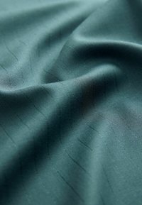Dark teal fabric with a smooth texture, featuring subtle vertical pinstripes. The material appears lightweight and pliable, with a slight sheen.
